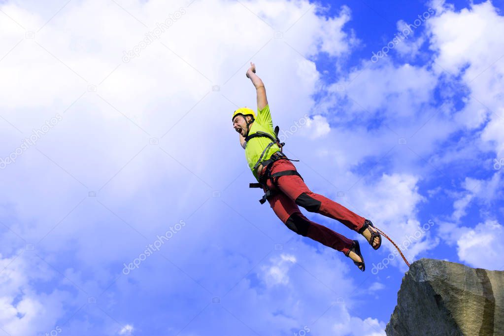 Jump rope from a high rock in the mountains.