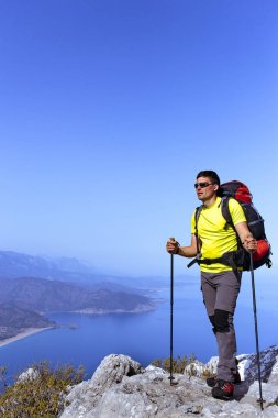 Sırt çantalı bir adam dağlarda yürüyüş yapıyor..