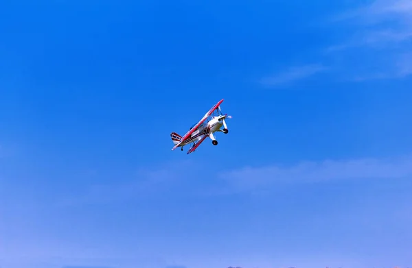 Vuelo de un avión deportivo contra un cielo azul . — Foto de Stock