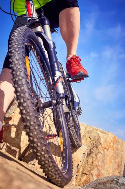 Güneşli bir yaz aylarında dağlara yolculuk eden bir bisikletçi