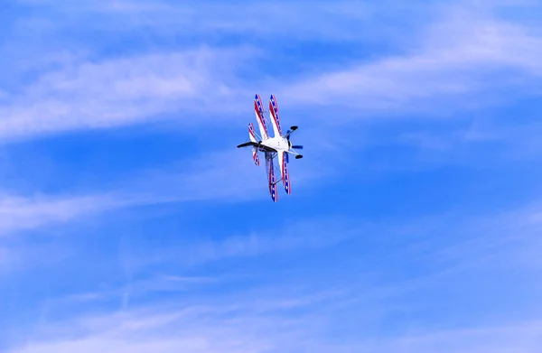 Vuelo de un avión deportivo contra un cielo azul . — Foto de Stock