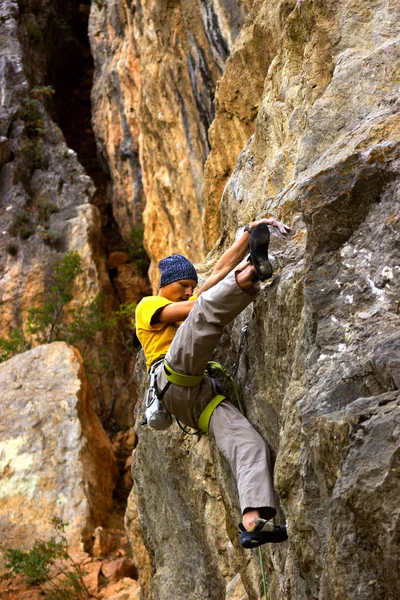 Молодой альпинист висит на скале с веревкой . — стоковое фото