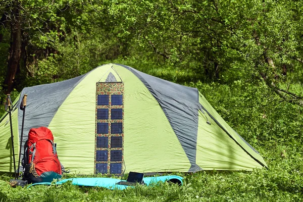 Camping en un claro en el bosque con una mochila y tienda de campaña . — Foto de Stock