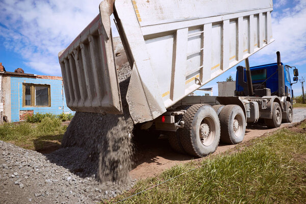 Разгрузка балласта на дороге в солнечный день
.
