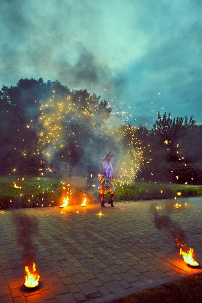 Dancing with fire in the dark on the street.