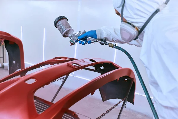 Painting the car's bumper red on the service.