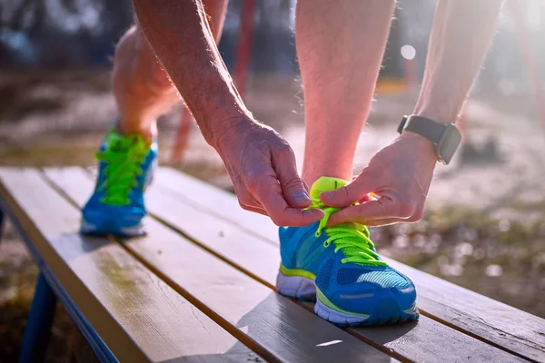 Atar cordones de zapatos en zapatillas durante los deportes al aire libre de clase . — Foto de Stock