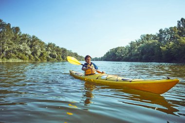 Nehir boyunca ormanda yaz boyunca kano gezisi.