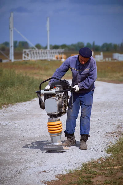 Vagando pela estrada com uma ferramenta vibratória em um dia ensolarado . — Fotografia de Stock