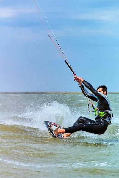 Mann beim Kitesurfen auf den Wellen im Sommer. — Stockfoto