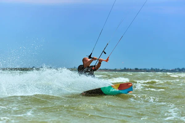 Mann beim Kitesurfen auf den Wellen im Sommer. — Stockfoto