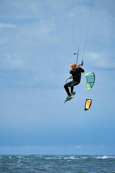 Uomo a cavallo di un kite surf sulle onde in estate . — Foto Stock