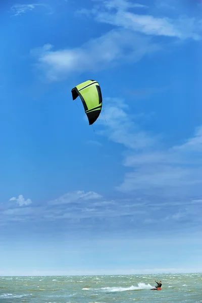 Homem montando um papagaio surfando nas ondas no verão . — Fotografia de Stock