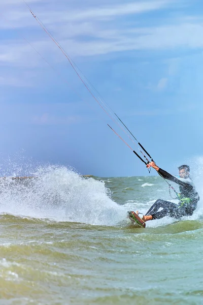 Mann beim Kitesurfen auf den Wellen im Sommer. — Stockfoto