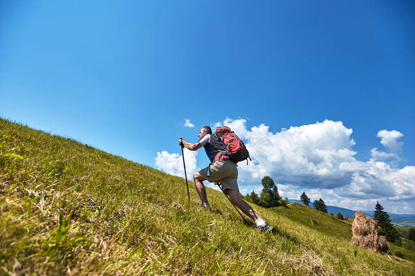 Hiking in the mountains in the summer with a backpack.