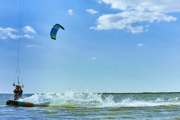 Чоловік катається на повітряному змії, що серфінгує на хвилях влітку . — стокове фото