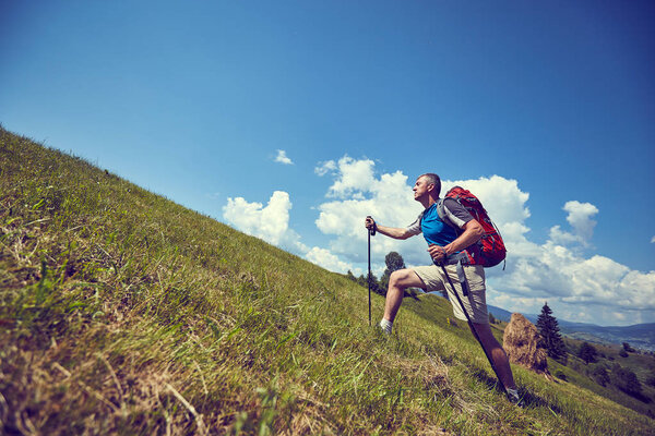 Hiking in the mountains in the summer with a backpack.