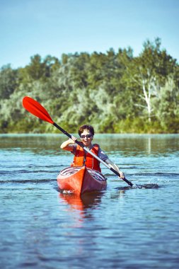 Nehir boyunca ormanda yaz boyunca kano gezisi.