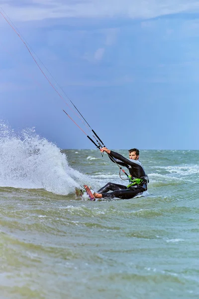 Mann beim Kitesurfen auf den Wellen im Sommer. — Stockfoto