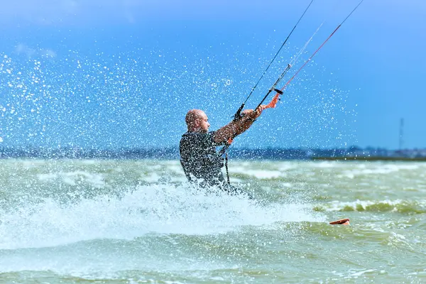 Mann beim Kitesurfen auf den Wellen im Sommer. — Stockfoto