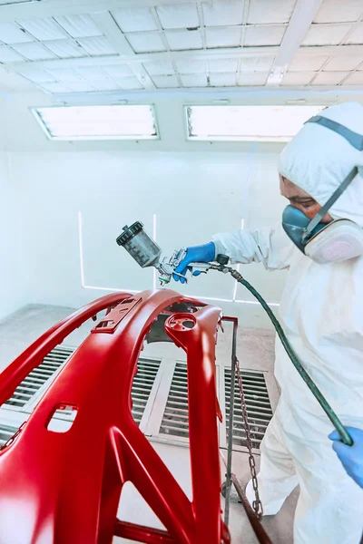 Painting bumpers machine red in the paint shop.