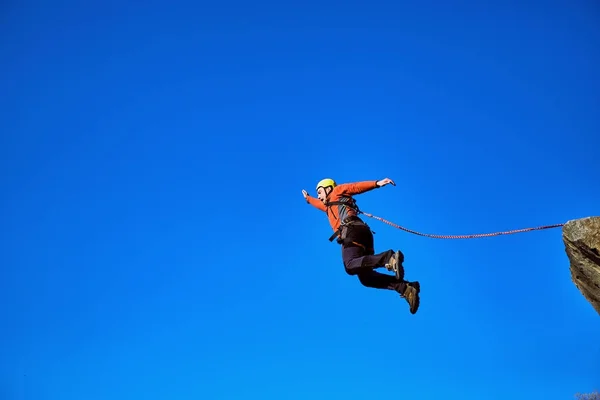 Mit einem Seil von der Klippe springen. — Stockfoto