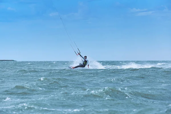 Mann beim Kitesurfen auf den Wellen im Sommer. — Stockfoto