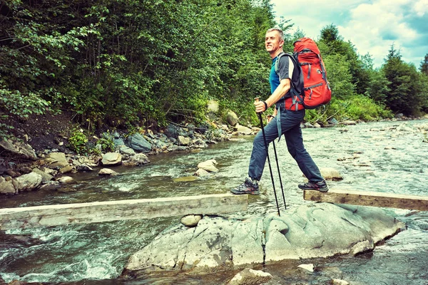 Senderismo en las montañas en verano con una mochila . — Foto de Stock