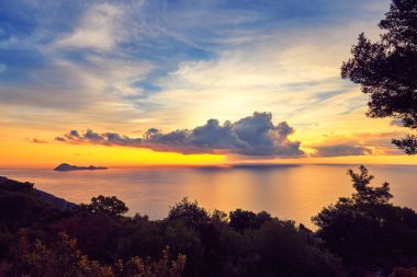 Günbatımı ile bulutlar deniz manzaralı.