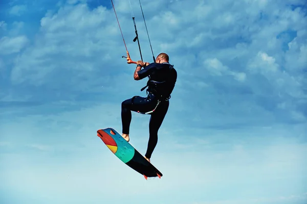 Man rijden een kite surfen op de golven in de zomer. — Stockfoto