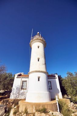 Beyaz bir deniz feneri altında sahil yolunda gösteren