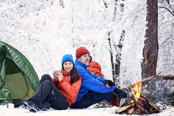 Télen camping egy sátrat, és tüzet az erdő. — Stock Fotó