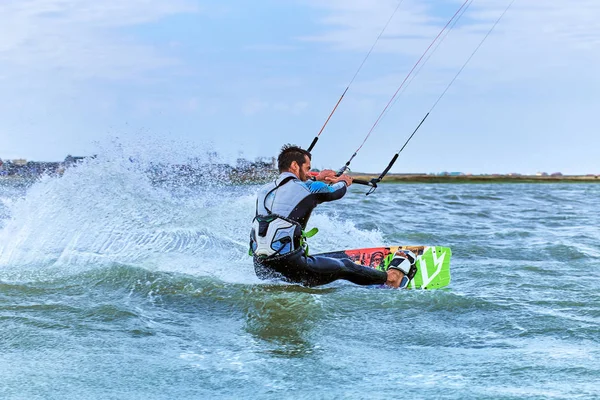 Uomo a cavallo di un kite surf sulle onde in estate . — Foto Stock