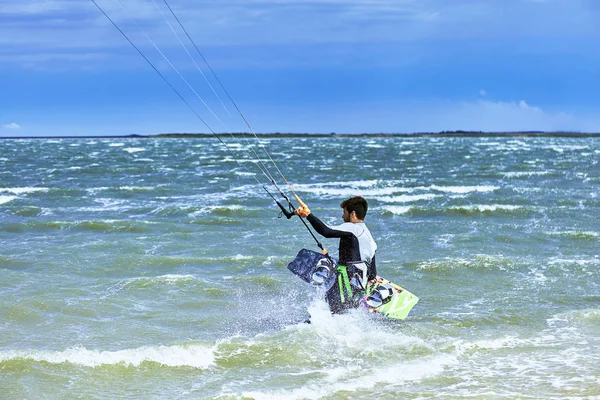 Uomo a cavallo di un kite surf sulle onde in estate . — Foto Stock