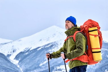 Bir sırt çantası ile dağın tepesine tırmanmaya kış.