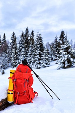 Arka karşı bir kış kampanyası içinde kar üzerinde kırmızı bir sırt çantası