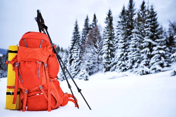Uma mochila vermelha na neve em uma campanha de inverno contra as costas — Fotografia de Stock