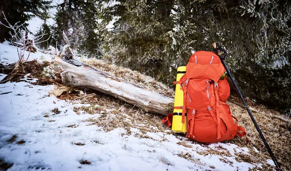 A red backpack on the snow in a winter campaign against the back — Stock Photo, Image