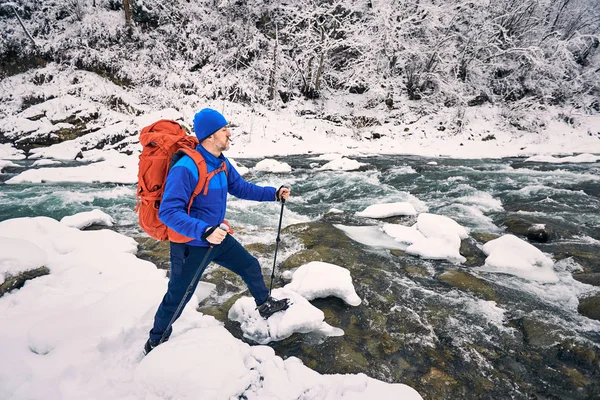 Caminhada de inverno com uma mochila em uma área montanhosa perto do rio — Fotografia de Stock