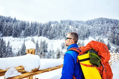 Bir sırt çantası ile dağın tepesine tırmanmaya kış.
