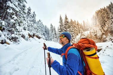 Bir sırt çantası ile dağın tepesine tırmanmaya kış.