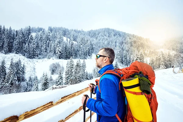 Bir sırt çantası ile dağın tepesine tırmanmaya kış.