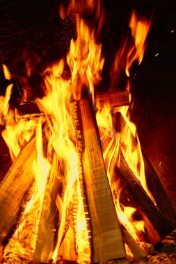 Karanlık bir arka plan üzerinde şömine odun yanan.