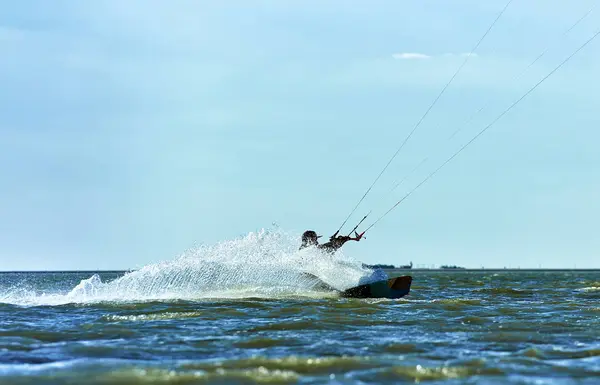 Man rijden een kite surfen op de golven in de zomer. — Stockfoto