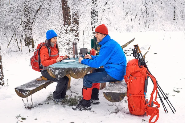 Preparando a refeição na caminhada de inverno na mesa no acampamento — Fotografia de Stock