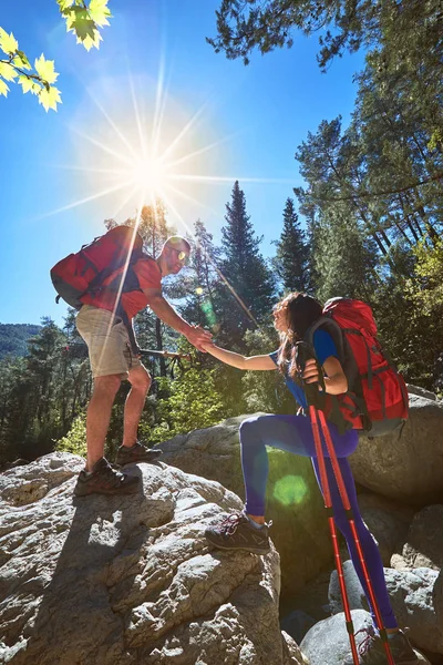 En hjälpande hand för en flicka höga berg i en vandring. — Stockfoto