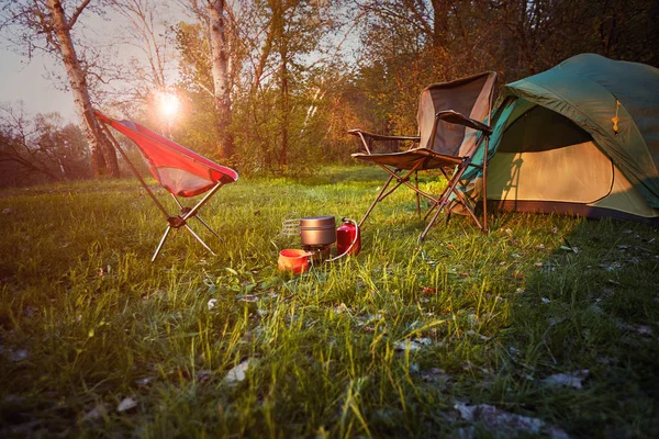 Camping in the woods with a backpack and a tent on the banks of