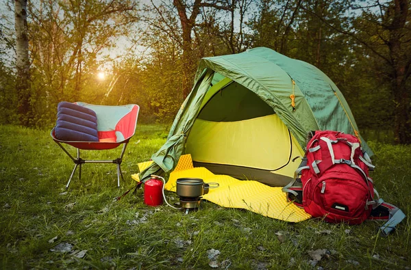 Camping en el bosque con una mochila y una tienda de campaña a orillas del — Foto de Stock