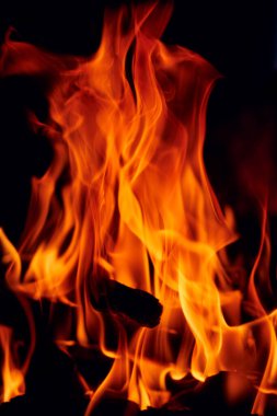 Şöminenin siyah arka planında alev dilleri.
