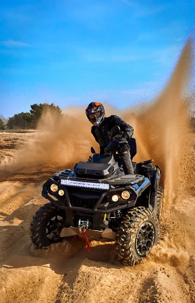 Racing powerful quad bike on the difficult sand in the summer.